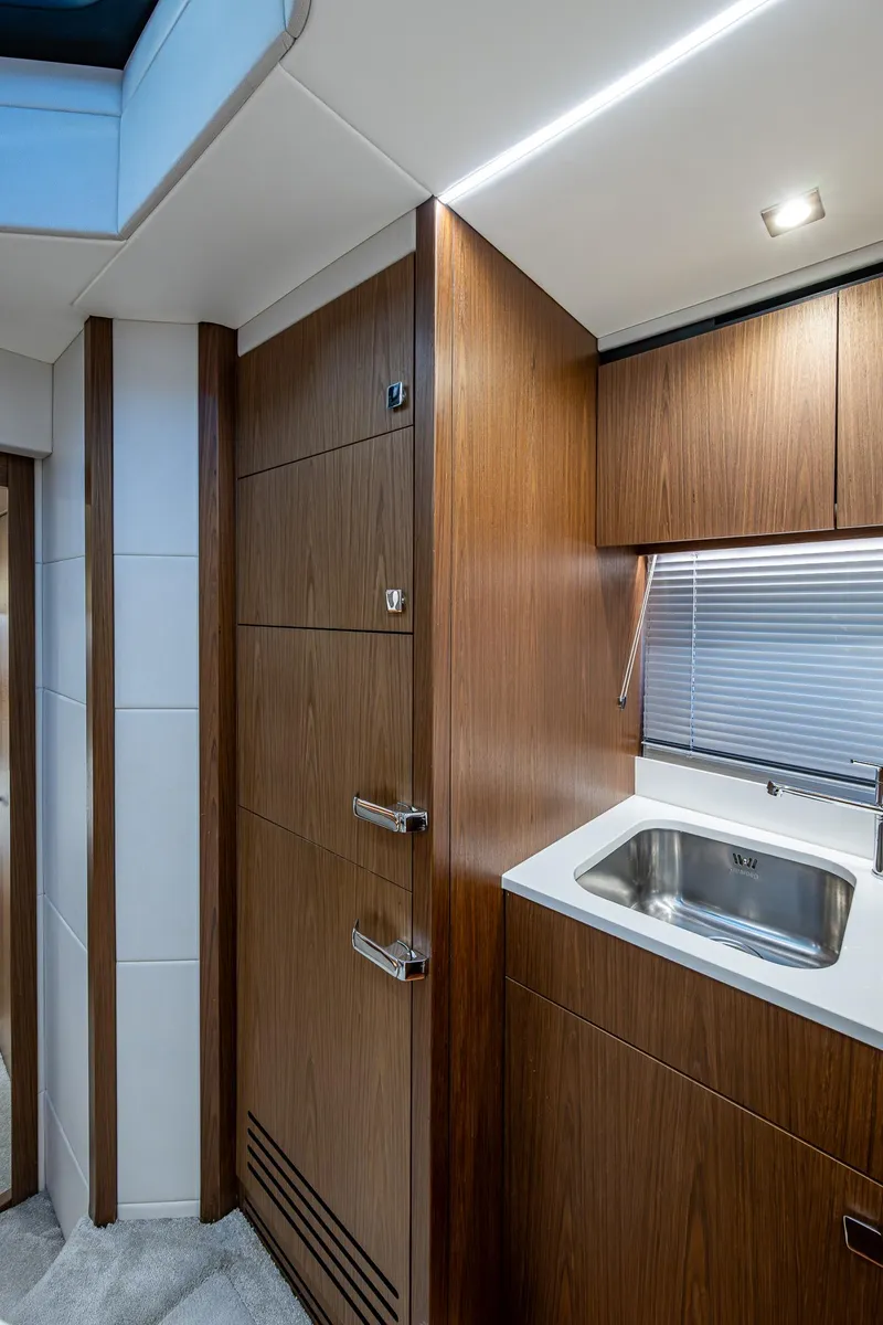 Slide: The Image of 2019 Sunseeker Predator 50 yacht interior with modern wood finish and compact sink area. - 47