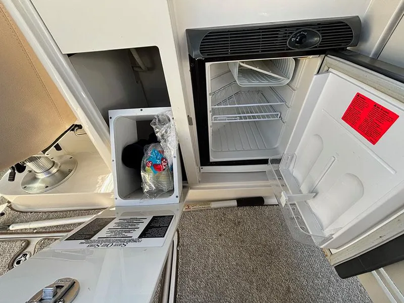 Slide: The Image of 2009 Sea Ray 290 Sundeck interior with open mini fridge and storage compartment. - 11