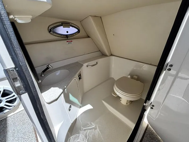 Slide: The Image of 2009 Sea Ray 290 Sundeck boat bathroom with sink, toilet, and porthole window. - 19