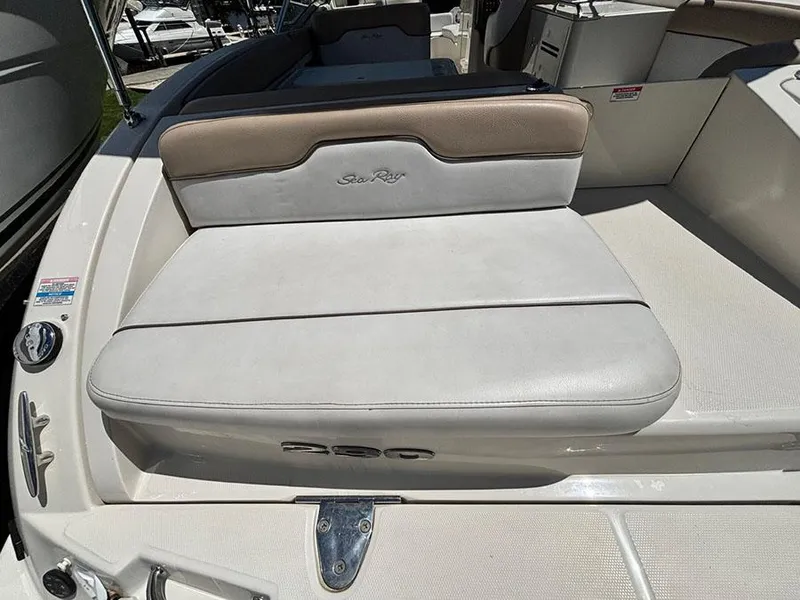 Slide: The Image of 2009 Sea Ray 290 Sundeck boat seating area with beige and white upholstery. - 5