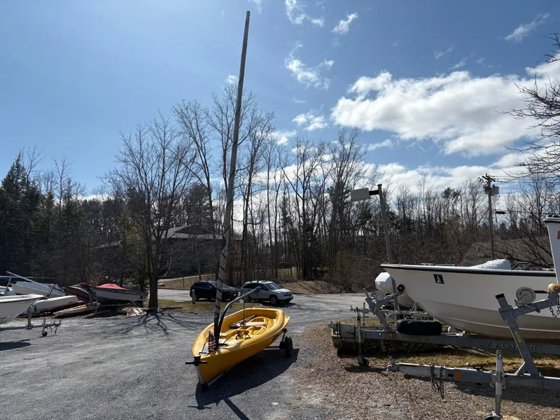 Slide: The Image of Boats and kayaks on trailers under a clear blue sky, Captiva Escape 2002 in background. - 4