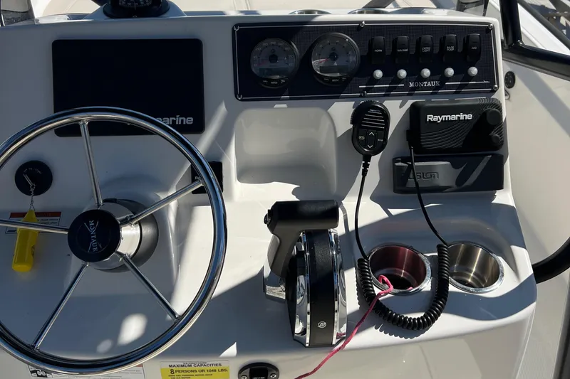 Slide: The Image of Control panel of 2022 Boston Whaler 190 Montauk boat with steering wheel and Raymarine electronics. - 13