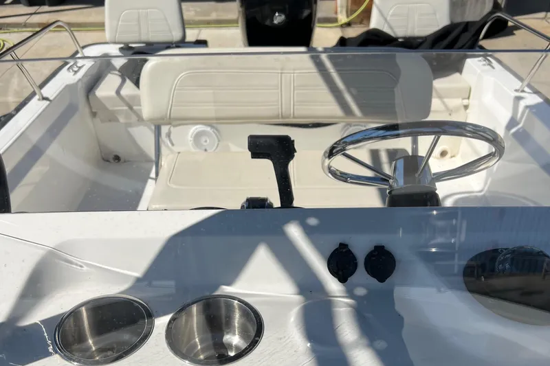 Slide: The Image of 2022 Boston Whaler 190 Montauk boat interior with steering wheel and seating. - 14