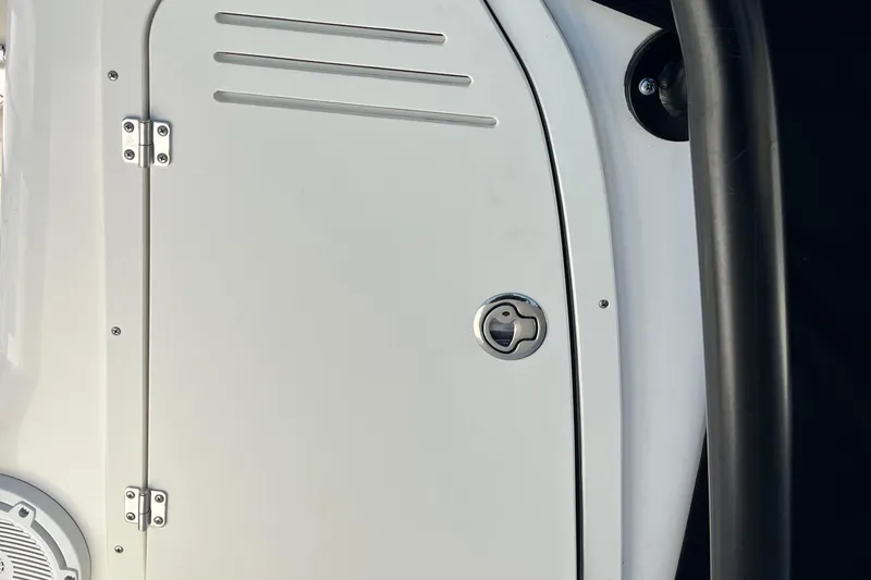 Slide: The Image of 2022 Boston Whaler 190 Montauk boat compartment door with latch and speaker detail. - 18