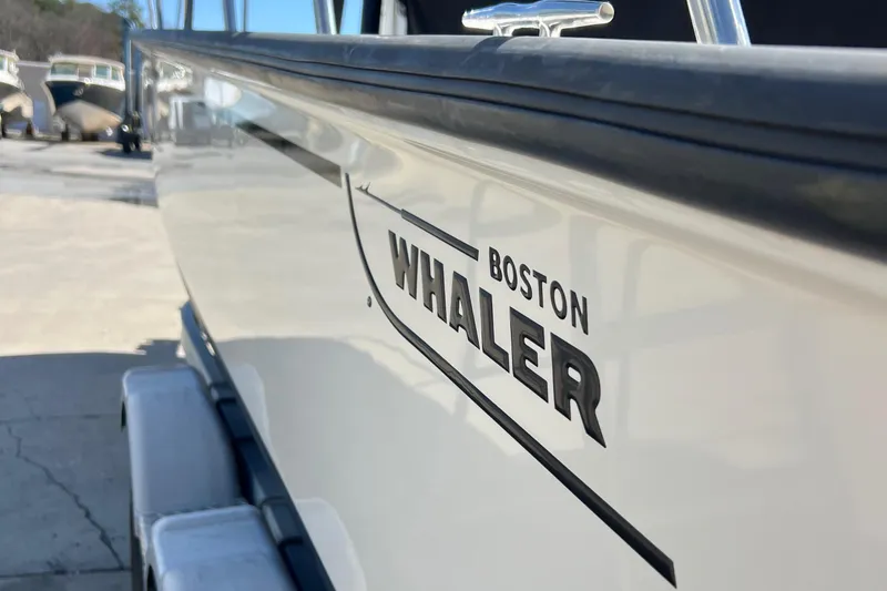 Slide: The Image of 2022 Boston Whaler 190 Montauk boat side view with logo, parked on a trailer. - 2