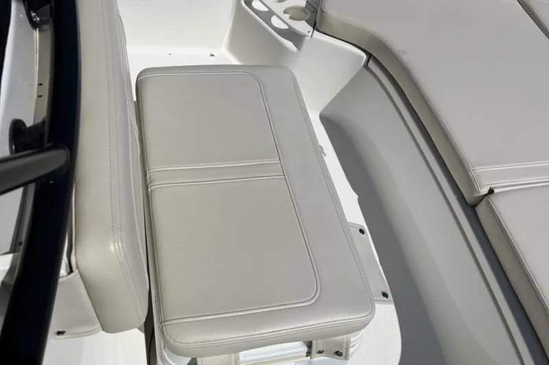 Slide: The Image of 2022 Boston Whaler 190 Montauk boat interior with cushioned seating and cup holders. - 7