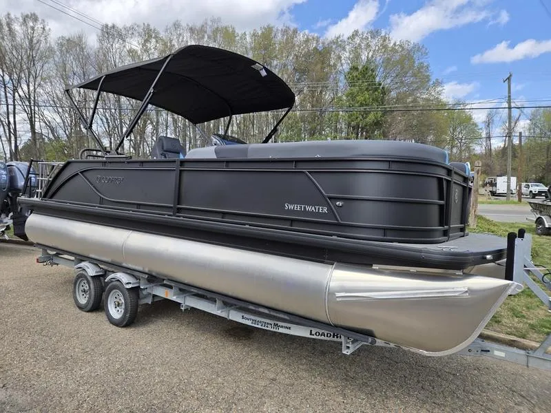 The Image of 2025 Godfrey Sweetwater 2286 SFLC pontoon boat on trailer, black exterior, under blue sky. - 0