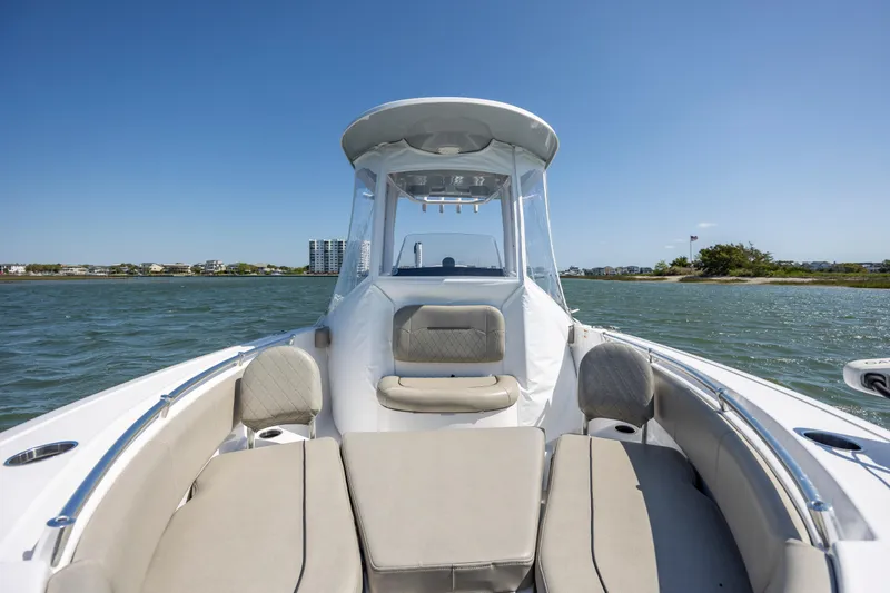 Slide: The Image of 2022 Sportsman Open 232 Center Console boat on water, featuring spacious seating and clear skies. - 16