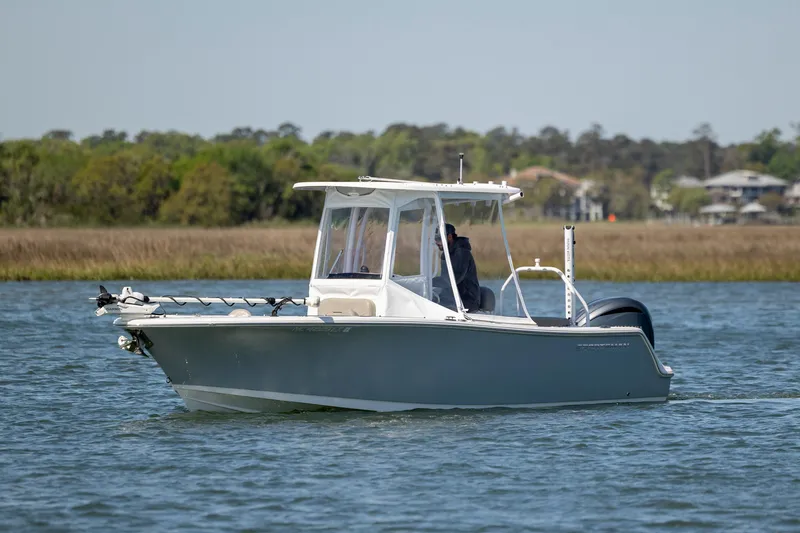Slide: The Image of 2022 Sportsman Open 232 Center Console boat on calm water, surrounded by greenery. - 3