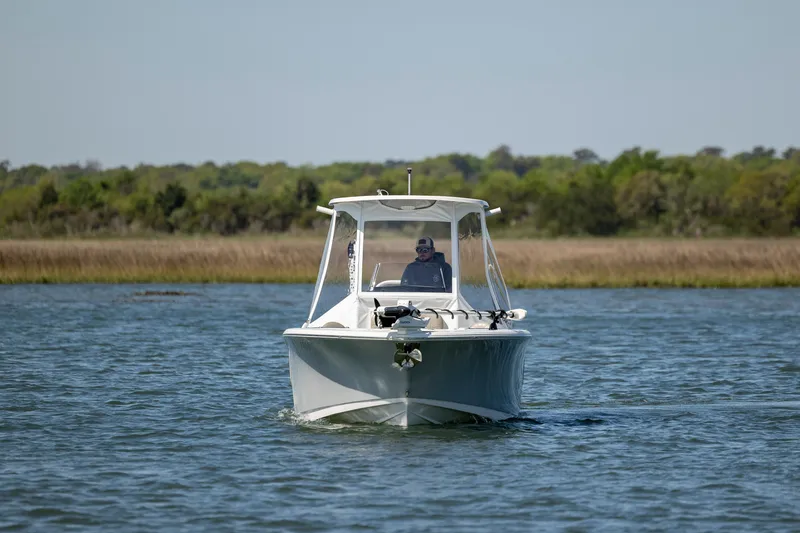 Slide: The Image of 2022 Sportsman Open 232 Center Console boat cruising on a calm lake. - 7