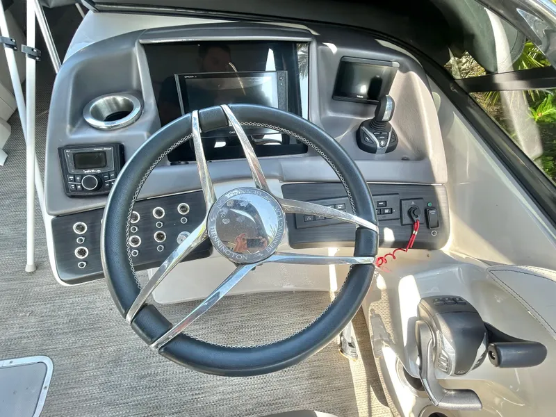 Slide: The Image of Steering wheel and dashboard of a 2021 Bennington 30 boat, featuring modern controls and display. - 10