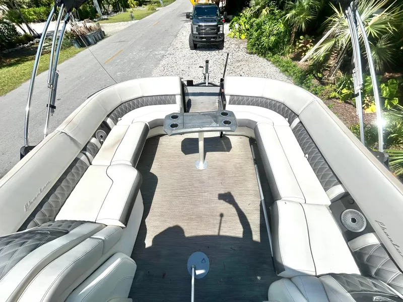 Slide: The Image of 2021 Bennington 30 boat interior with plush seating and a scenic road view. - 15