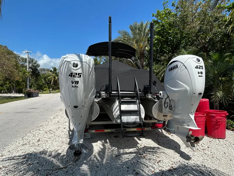 Slide: The Image of 2021 Bennington 30 boat with twin Yamaha 425 V8 engines, parked on gravel. - 5