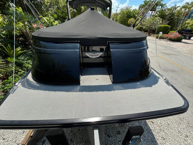 Slide: The Image of 2021 Bennington 30 boat with black cover, parked outdoors on a sunny day. - 6