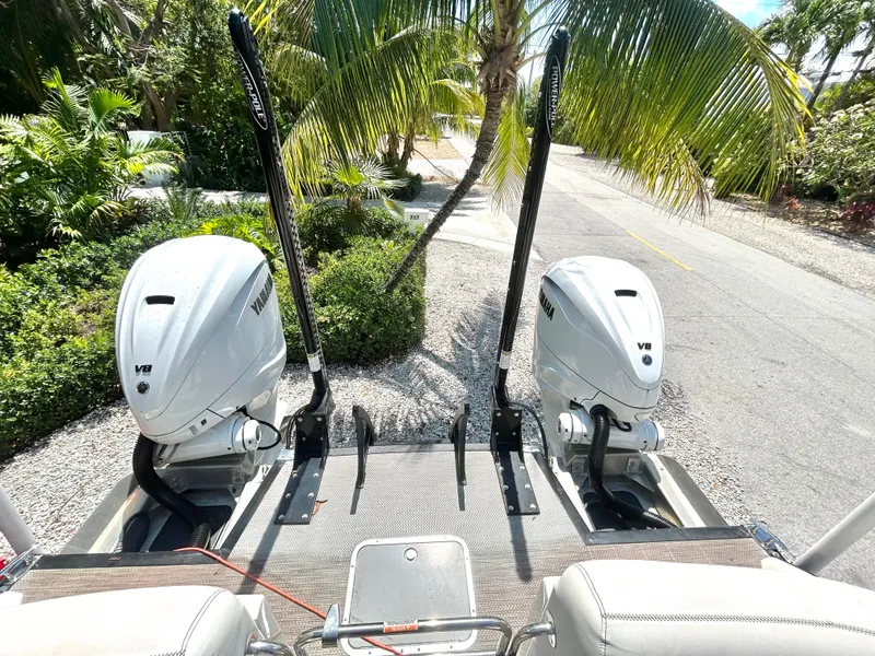 Slide: The Image of 2021 Bennington 30 boat with dual V8 engines, parked near tropical palm trees. - 8