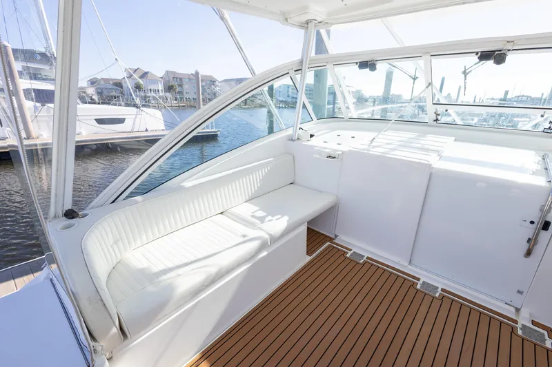 Slide: The Image of 2005 Luhrs 36 yacht interior with white seating and wooden flooring at a marina. - 17