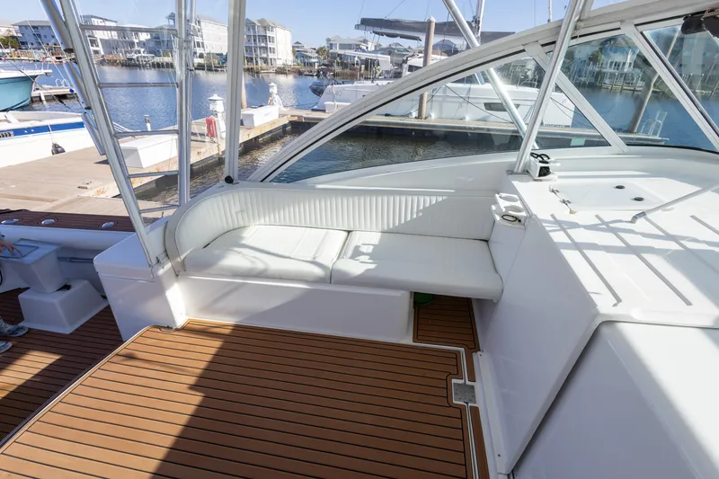 Slide: The Image of 2005 Luhrs 36 boat interior with white seating and wooden deck, docked at marina. - 21