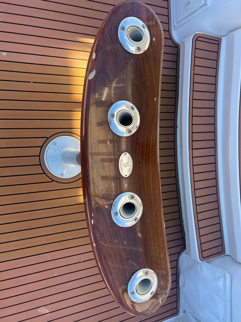 Slide: The Image of 2005 Luhrs 36 boat deck with wooden rod holders and teak flooring. - 26