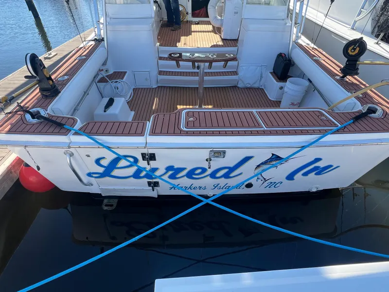 Slide: The Image of 2005 Luhrs 36 boat docked, named "Lured In," featuring a spacious deck and fishing equipment. - 28