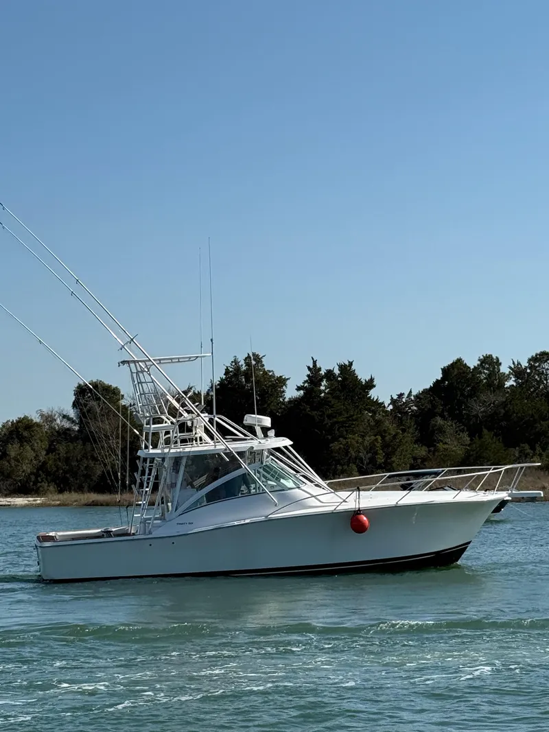 Slide: The Image of 2005 Luhrs 36 boat on calm water with trees in the background. - 5