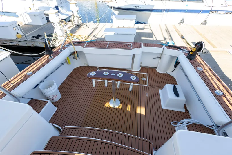 Slide: The Image of 2005 Luhrs 36 boat deck with wooden flooring and fishing rod holders. - 8