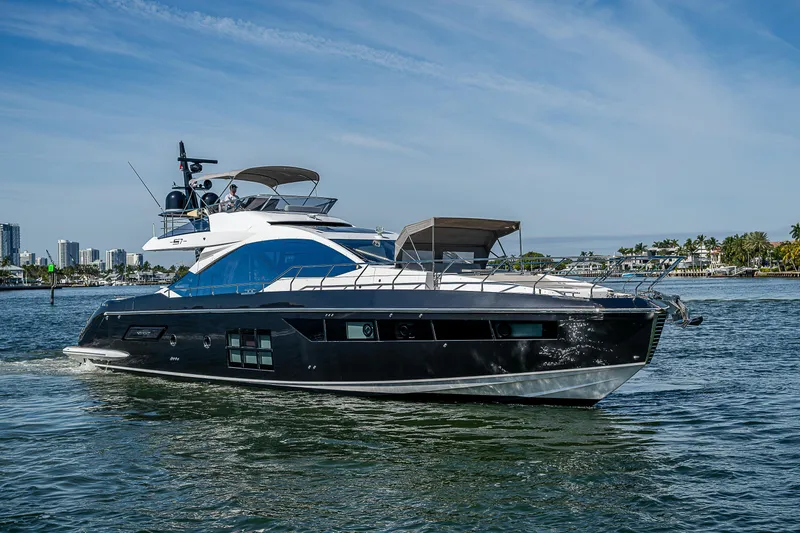 Slide: The Image of 2019 Azimut S7 yacht cruising on a sunny day, with city skyline in background. - 1