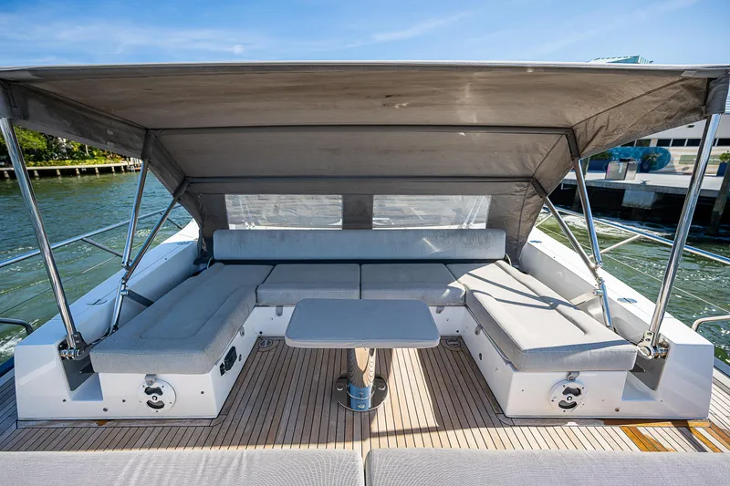 Slide: The Image of 2019 Azimut S7 yacht with shaded deck seating and table, docked by the water. - 12