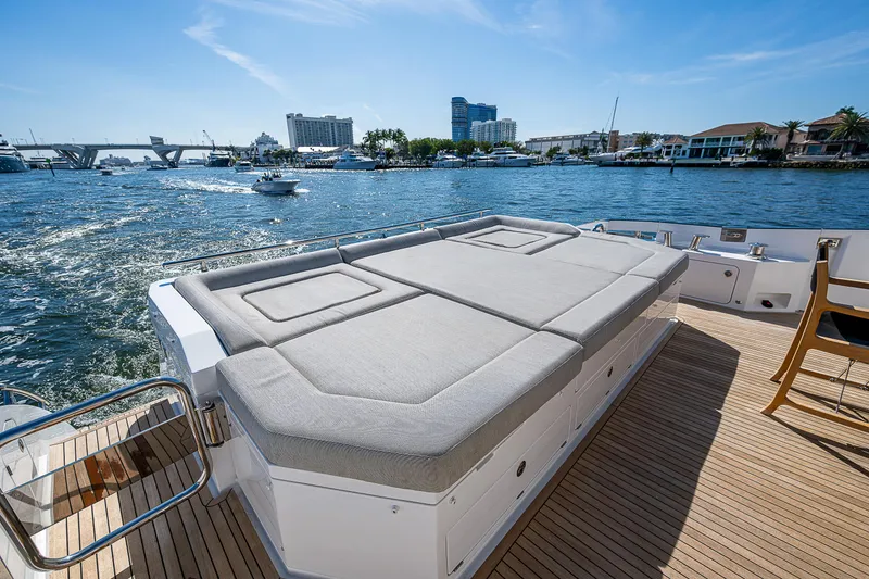 Slide: The Image of 2019 Azimut S7 yacht deck with sunbed, overlooking a scenic waterfront view. - 19