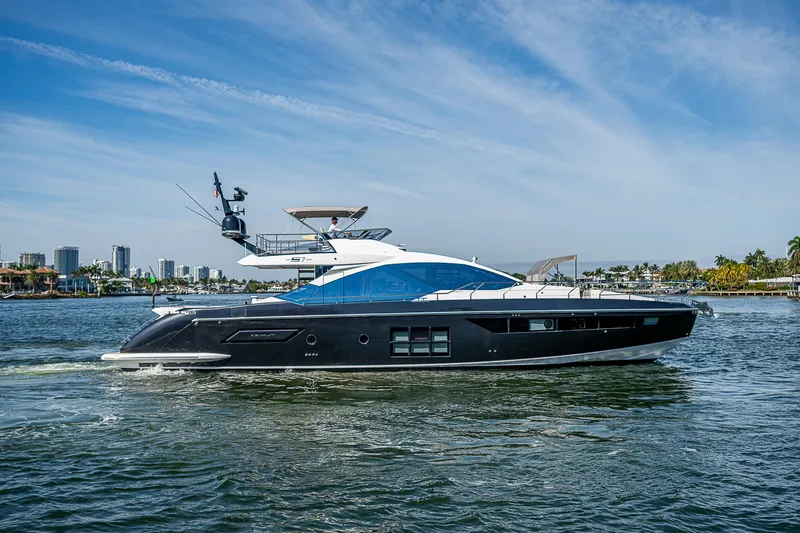 Slide: The Image of 2019 Azimut S7 yacht cruising on a sunny day, with city skyline in the background. - 3
