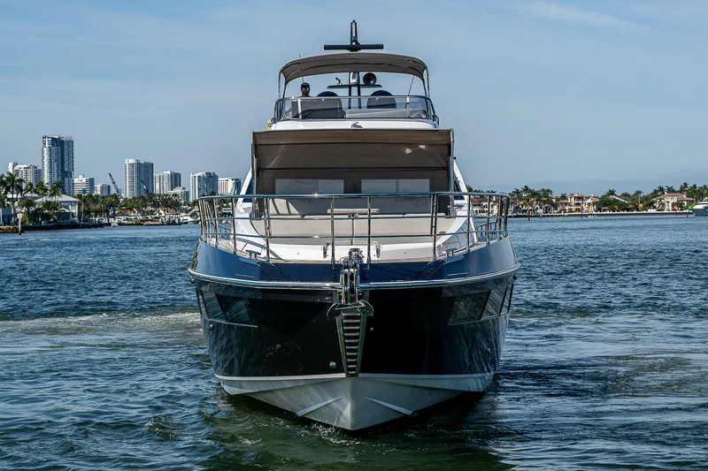 Slide: The Image of 2019 Azimut S7 yacht cruising on a sunny day with city skyline backdrop. - 4