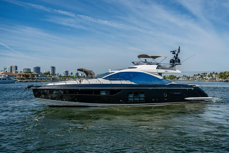 Slide: The Image of 2019 Azimut S7 yacht cruising on a sunny day with city skyline in background. - 6