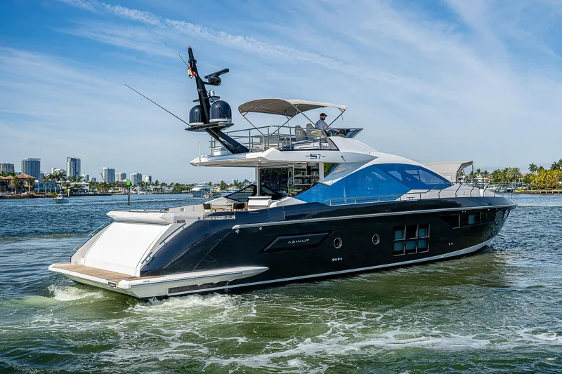 Slide: The Image of 2019 Azimut S7 yacht cruising on a sunny day with city skyline in background. - 9