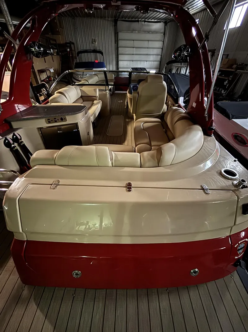 Slide: The Image of 2022 Avalon Excalibur Elite Windshield boat with luxurious seating and sleek design in a storage facility. - 13