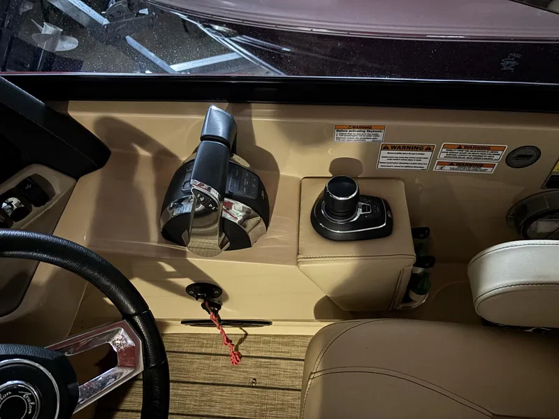 Slide: The Image of 2022 Avalon Excalibur Elite Windshield boat dashboard with controls and steering wheel. - 23