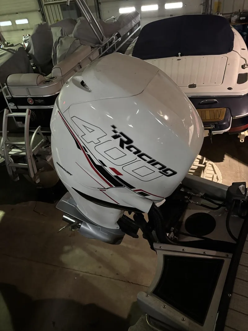 Slide: The Image of 2022 Avalon Excalibur Elite Windshield with Racing 400 outboard motor in a garage setting. - 26