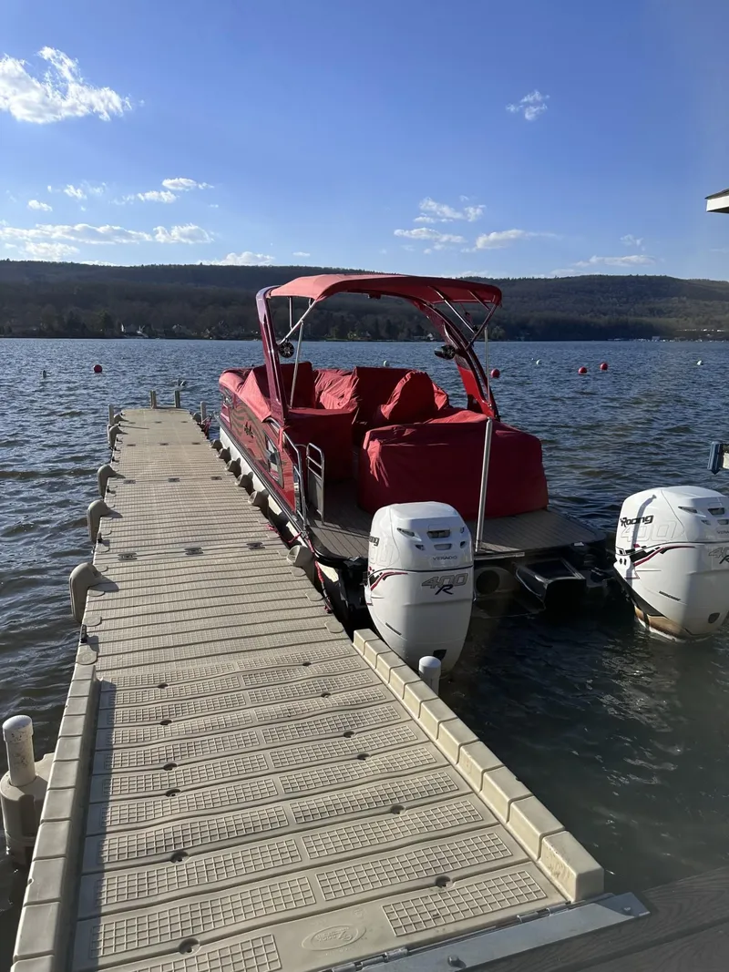Slide: The Image of 2022 Avalon Excalibur Elite Windshield boat docked on a sunny lake. - 4