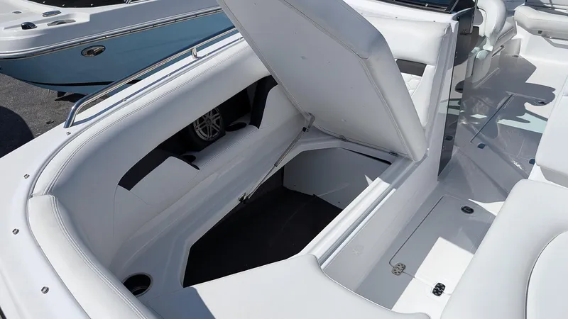 Slide: The Image of 2025 Four Winns HD8 OB boat interior with open storage compartment, showcasing sleek white seating. - 22