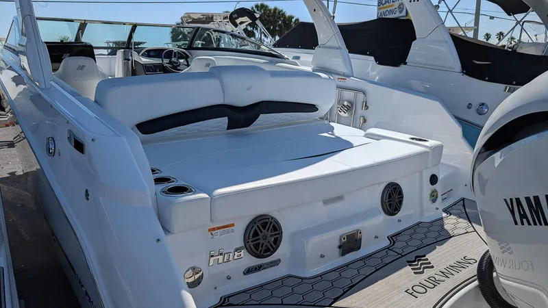 Slide: The Image of 2025 Four Winns HD8 OB boat with white seating and Yamaha engine, docked in sunlight. - 4