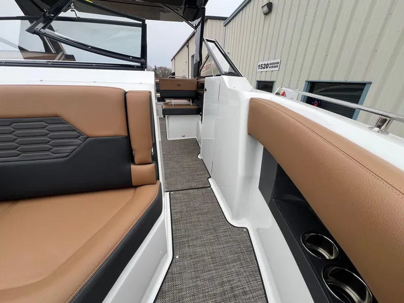 Slide: The Image of 2023 Cobalt A29 boat interior with tan and black seating, cup holders, and modern design. - 11