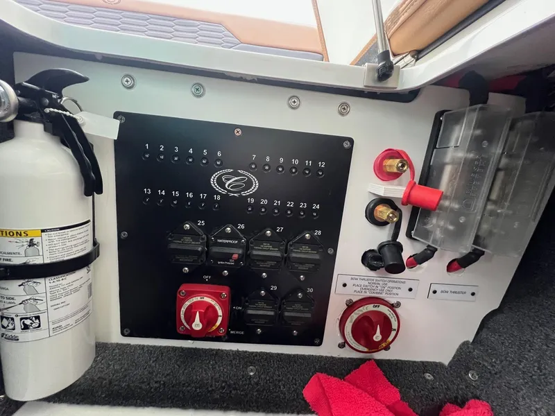 Slide: The Image of Control panel of 2023 Cobalt A29 boat with fire extinguisher and switches. - 32