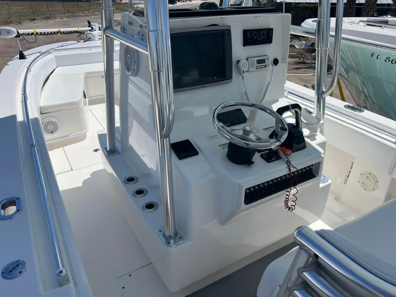 Slide: The Image of 2013 Contender 28 Sport boat console with steering wheel and electronic controls. - 10
