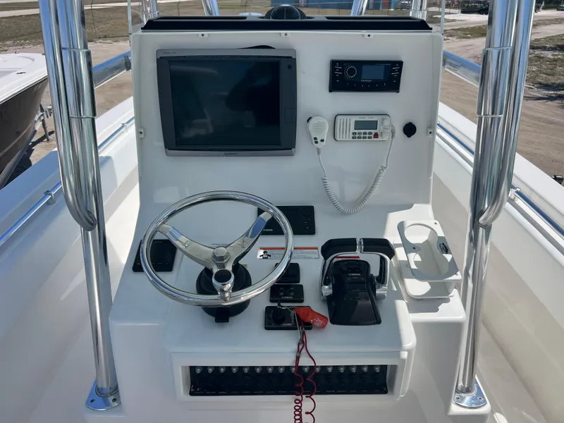 Slide: The Image of Control panel of a 2013 Contender 28 Sport boat with steering wheel and navigation equipment. - 11