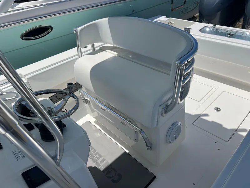 Slide: The Image of 2013 Contender 28 Sport boat interior with white seating and steering wheel. - 16