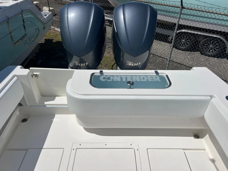Slide: The Image of 2013 Contender 28 Sport boat with dual 300 horsepower engines, docked near a trailer. - 18