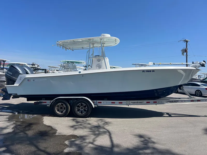 Slide: The Image of 2013 Contender 28 Sport boat on trailer, parked outdoors under clear blue sky. - 3