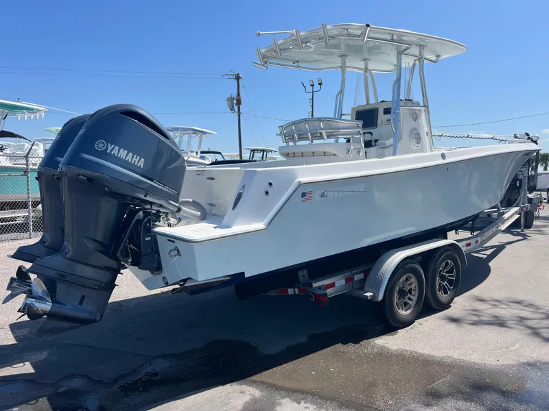 Slide: The Image of 2013 Contender 28 Sport boat on trailer with Yamaha outboard motor, parked outdoors. - 5