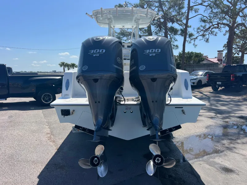 Slide: The Image of 2013 Contender 28 Sport boat with twin 300 HP engines, parked outdoors. - 6