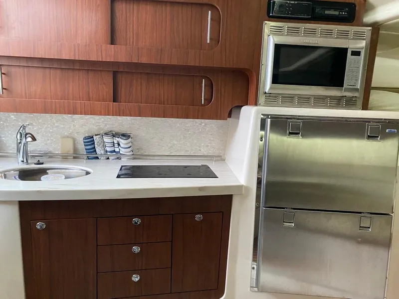 Slide: The Image of 2017 Grady-White Express 370 boat kitchen with sink, stove, microwave, and stainless steel fridge. - 21