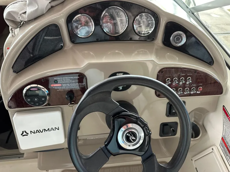 Slide: The Image of 2008 Sea Ray 260 Sundancer dashboard with steering wheel and Navman system. - 3