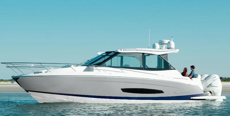 The Image of 2026 Regal 36 XO boat cruising on calm waters under clear blue sky. - 0